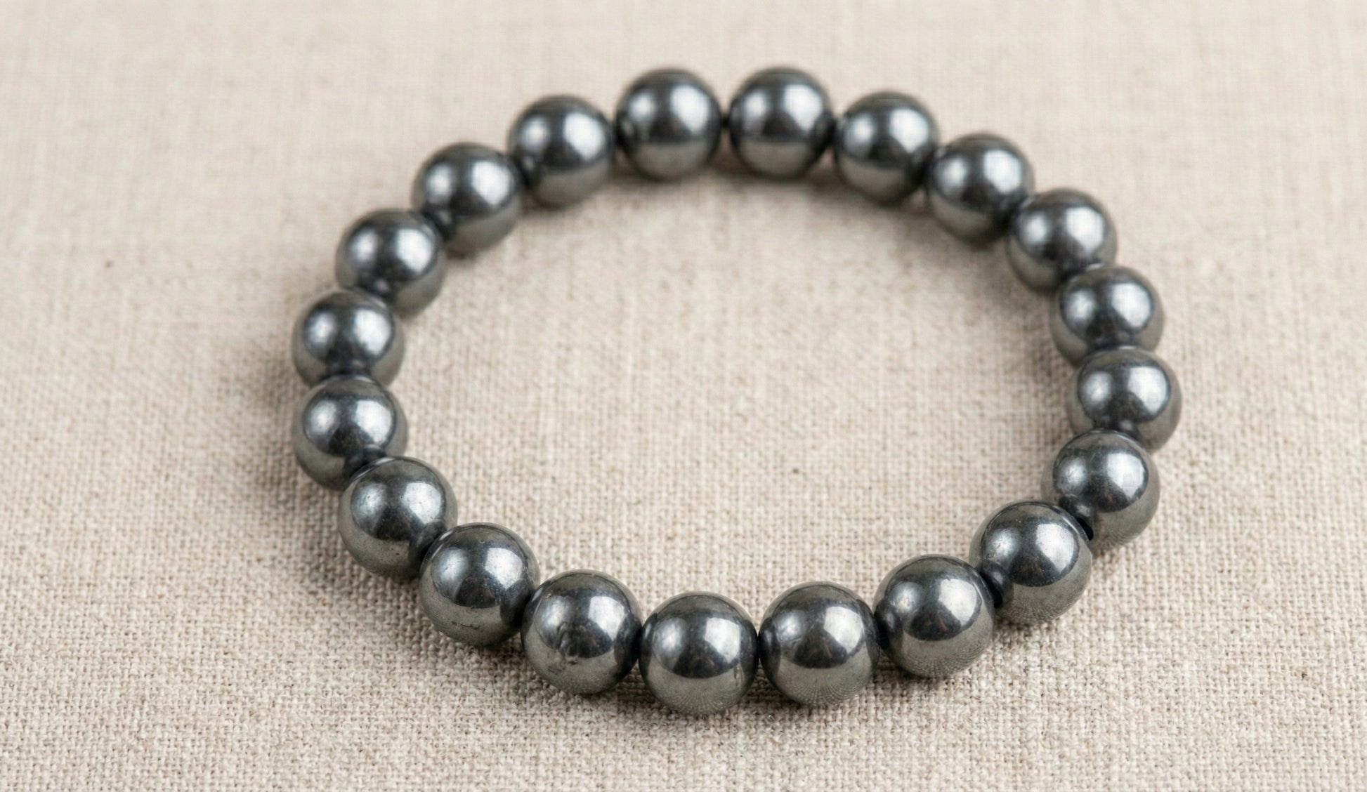 Hematite bead bracelet on beige fabric background