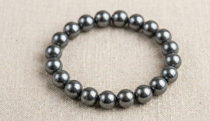 Hematite bead bracelet on beige fabric background
