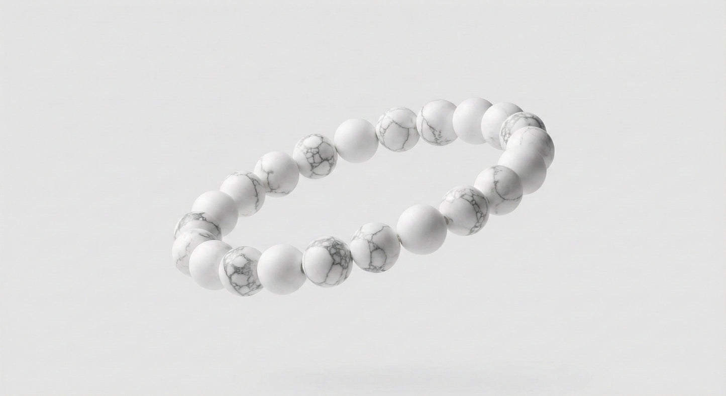 Floating white stone bead bracelet with gray marbling on a light gray background