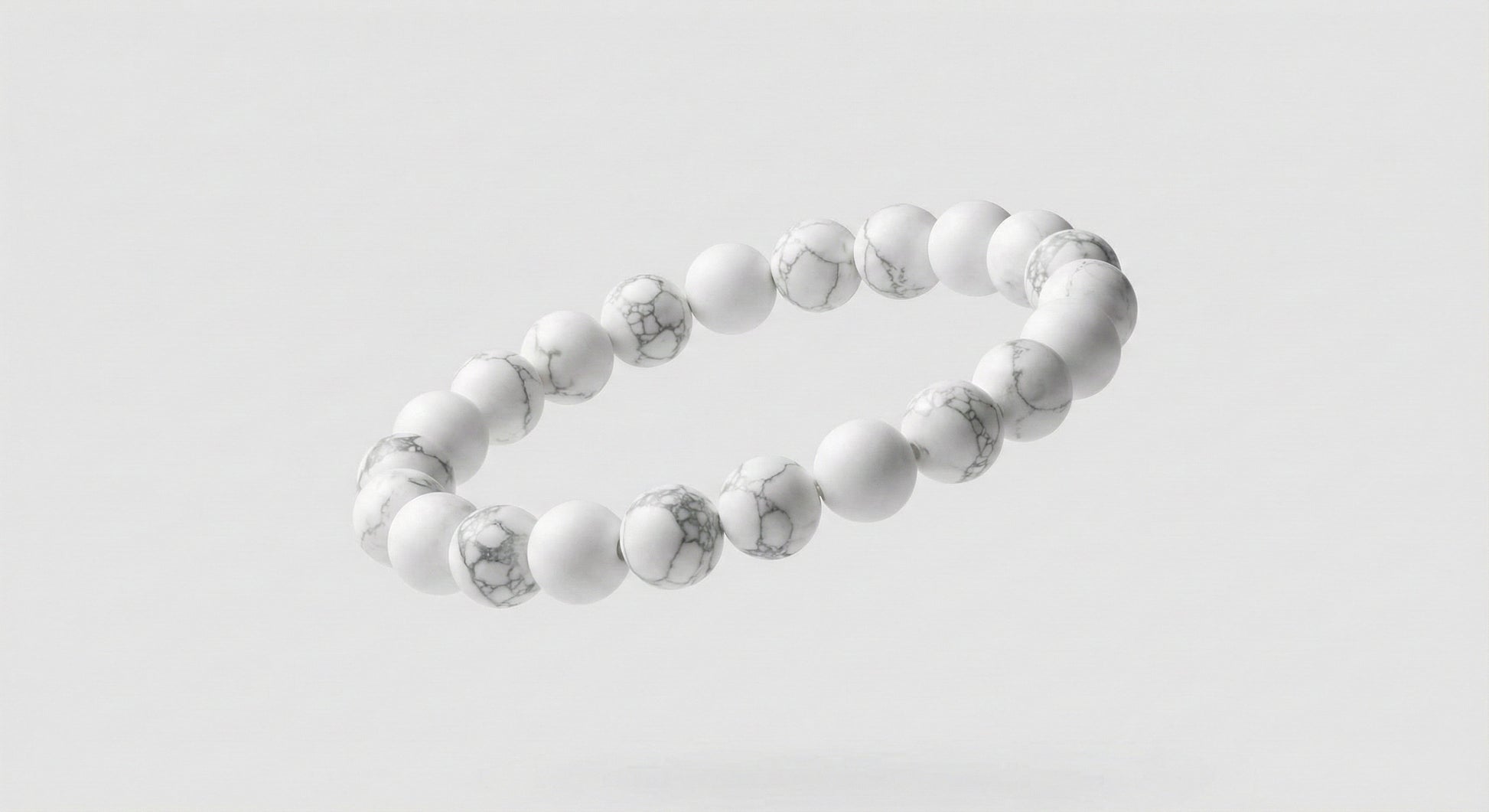 Floating white stone bead bracelet with gray marbling on a light gray background