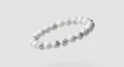 Floating white stone bead bracelet with gray marbling on a light gray background