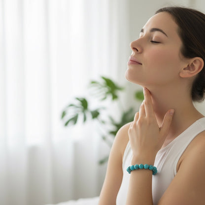 Young woman with closed eyes practicing mindfulness and wearing turquoise bead bracelet indoors
